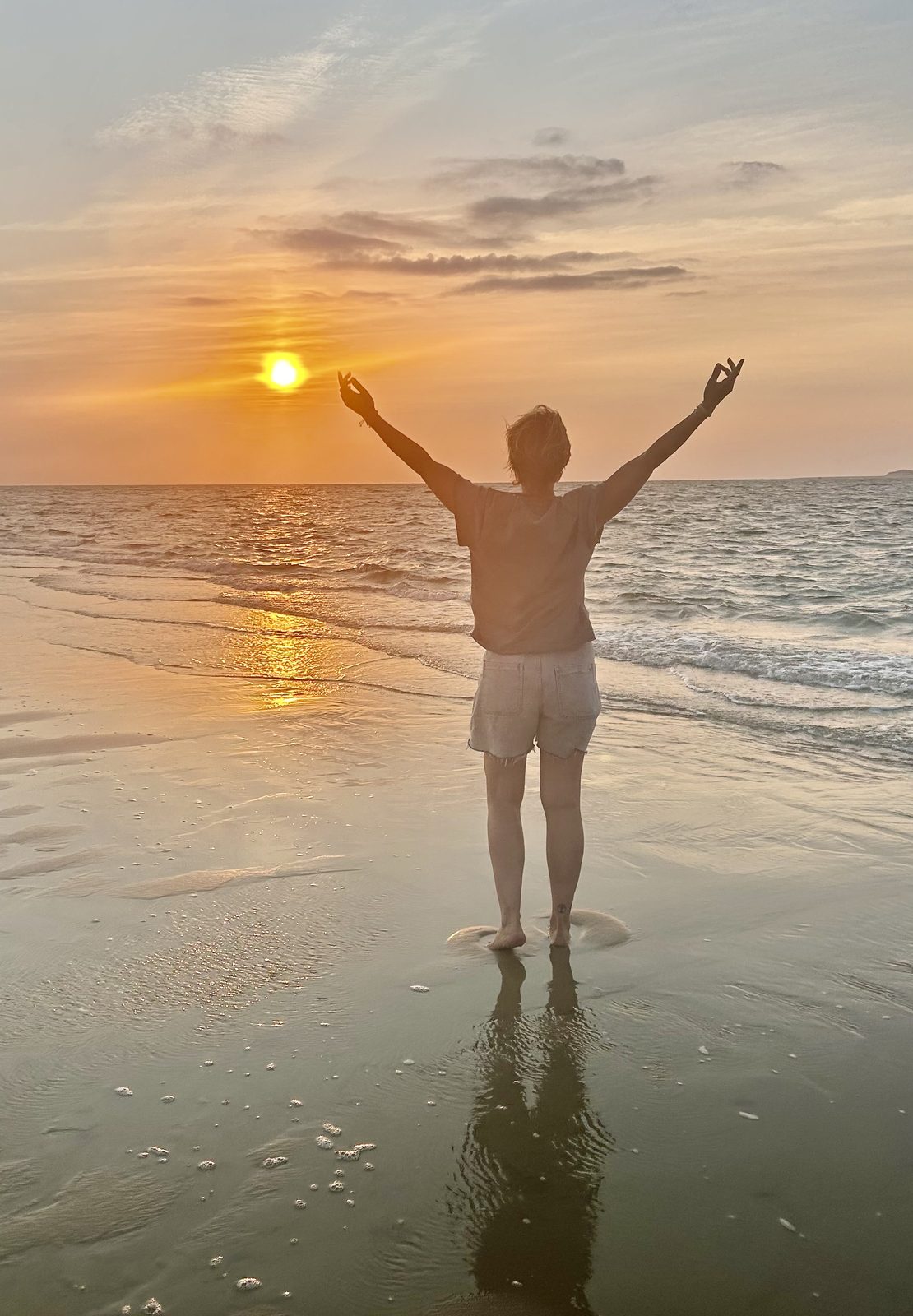 Sophrolates : femme bras levés face au coucher de soleil sur la plage, respiration et lâcher-prise, reconnexion à soi